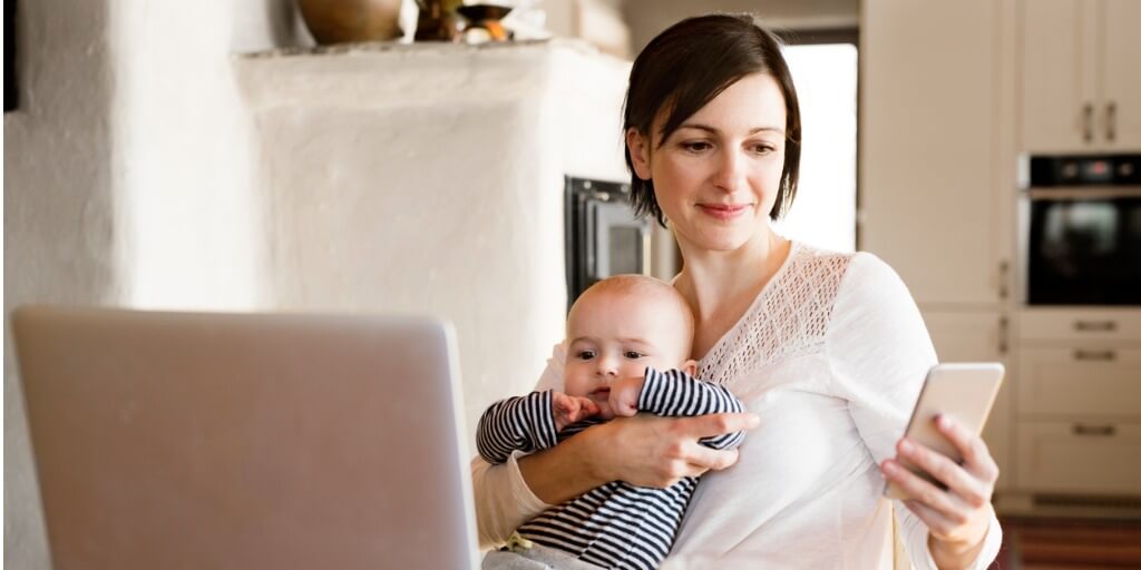 Self-service tools help customers meet their needs, even while multitasking. A customer holds her baby while checking a recent purchase.