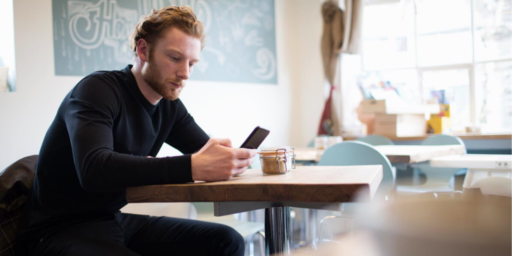 Homme dans un café avec un iPhone