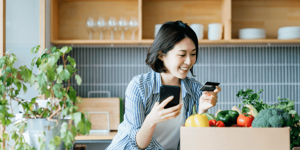 Una mujer está contenta con su experiencia de compra online en su cocina.